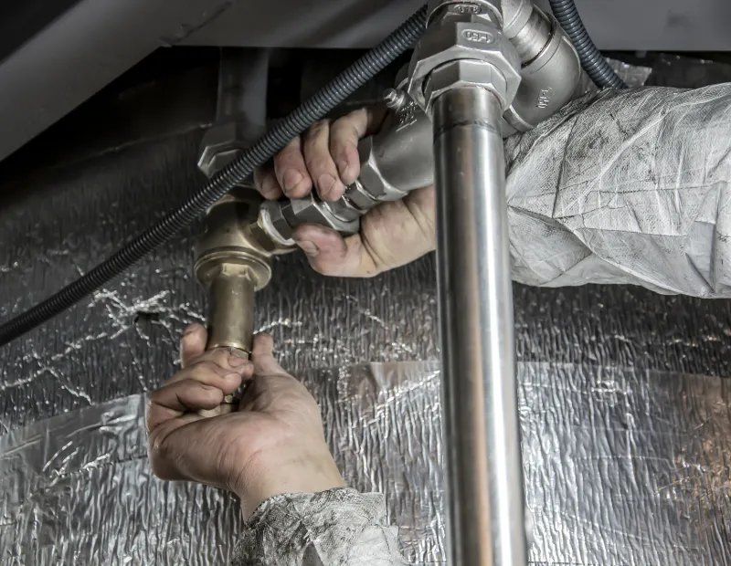 Reparación de tuberías efectiva y eficiente en Madrid imagen de fontanero arreglando un sistema de tuberías