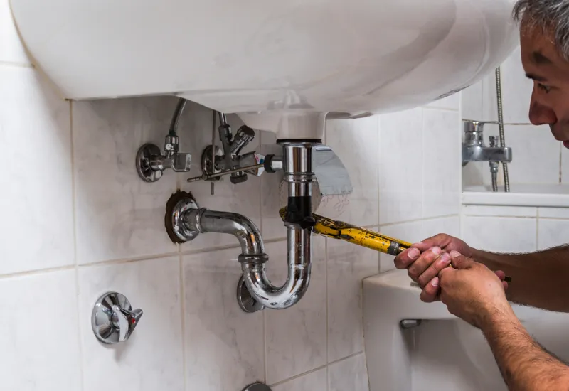 Servicios de fontanería profesional en el cuarto de baño en Madrid Fontanero realizando servicios de fontanería en el cuarto de baño de una casa en Madrid
